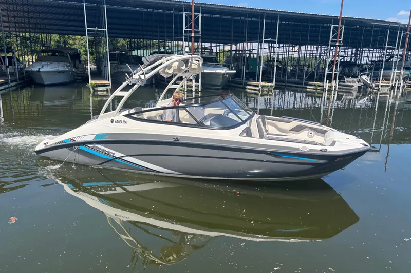 The Image of 2020 Yamaha Boats AR210 in marina, sleek design, calm water reflection. - 1