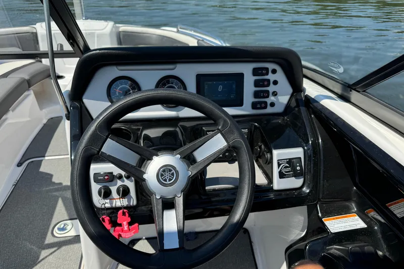 Slide: The Image of 2020 Yamaha AR210 boat dashboard with steering wheel and control panel on water. - 15