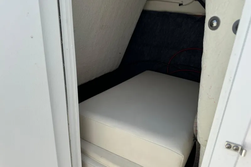 Slide: The Image of Interior storage compartment of a 2020 Yamaha AR210 boat, featuring a cushioned seat. - 17