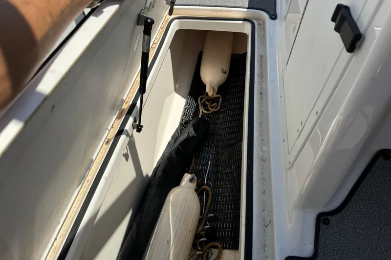 Slide: The Image of Storage compartment in a 2020 Yamaha AR210 boat, containing fenders and equipment. - 21