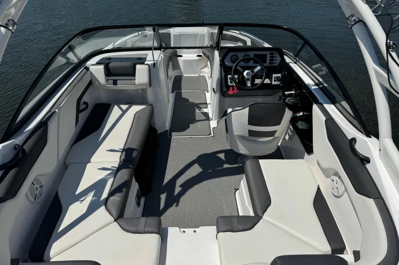 Slide: The Image of 2020 Yamaha Boats AR210 interior with seating and steering console on the water. - 7