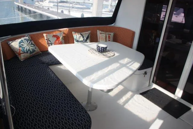 Slide: The Image of Interior seating area of 2008 Fountaine Pajot Orana 44 catamaran with table and cushions. - 19