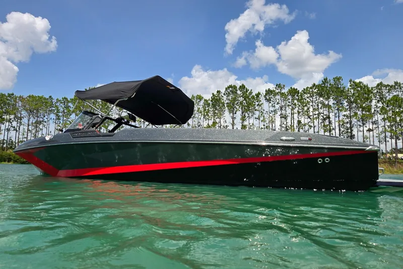 Slide: The Image of 2025 Nautique Ski Nautique boat on clear water, under a sunny sky with trees in the background. - 10