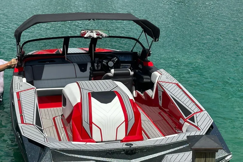Slide: The Image of 2025 Nautique Ski Nautique boat with red and white interior on clear water. - 11