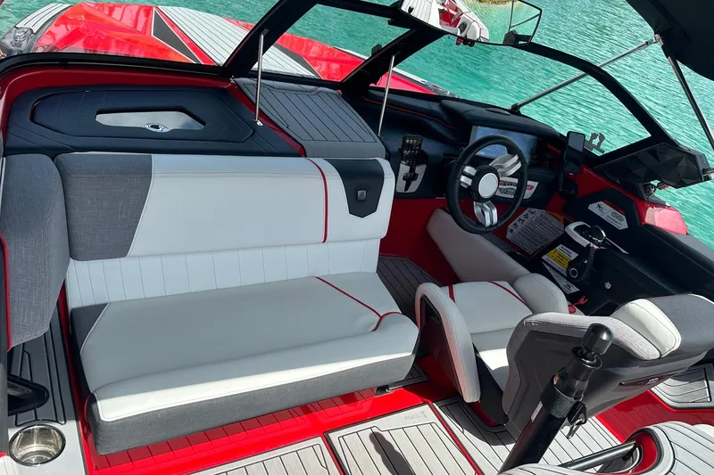 Slide: The Image of 2025 Nautique Ski Nautique boat interior with modern seating and steering, on turquoise water. - 3