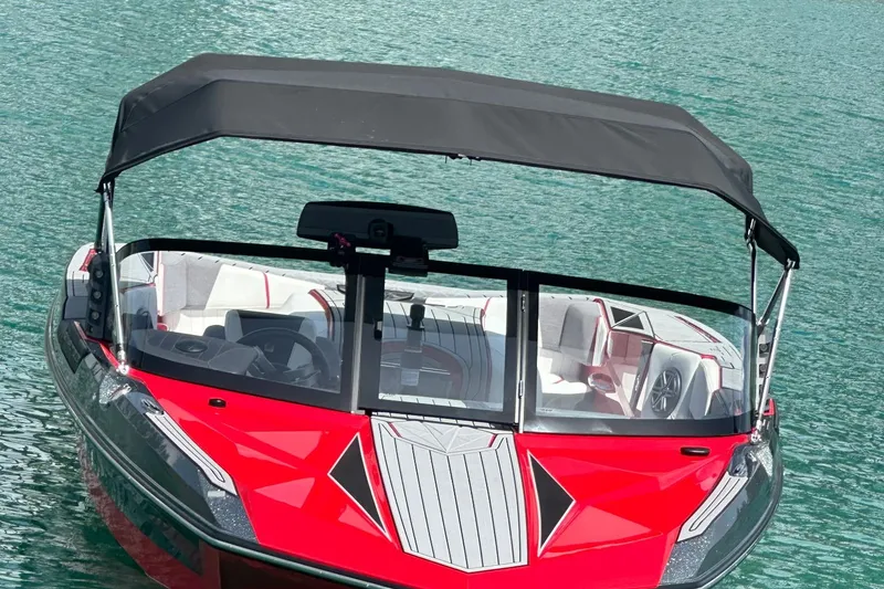 Slide: The Image of 2025 Nautique Ski Nautique boat with red and black design on clear water. - 4