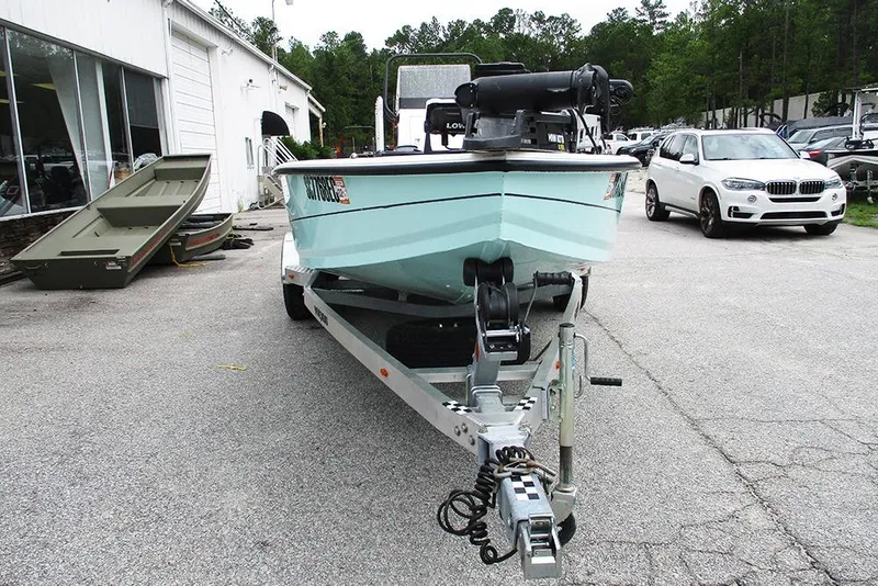 Slide: The Image of 2023 Vexus AVX2180CC boat on trailer, parked outside dealership with cars and trees nearby. - 4