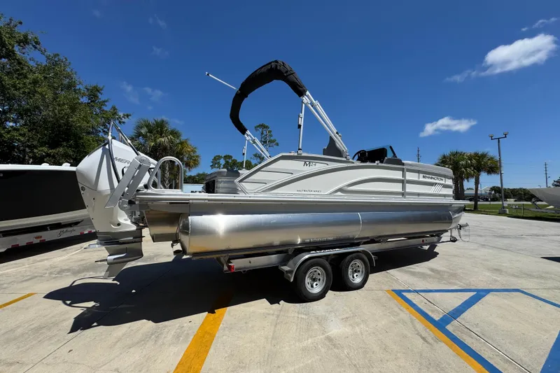 Slide: The Image of 2026 Bennington 24 MSB pontoon boat on trailer under clear blue sky. - 11