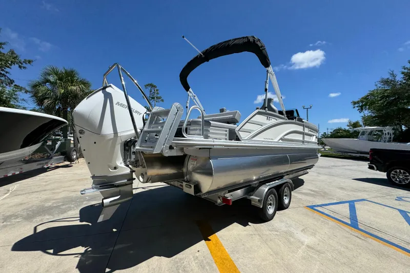 Slide: The Image of 2026 Bennington 24 MSB pontoon boat on trailer under clear blue sky. - 12