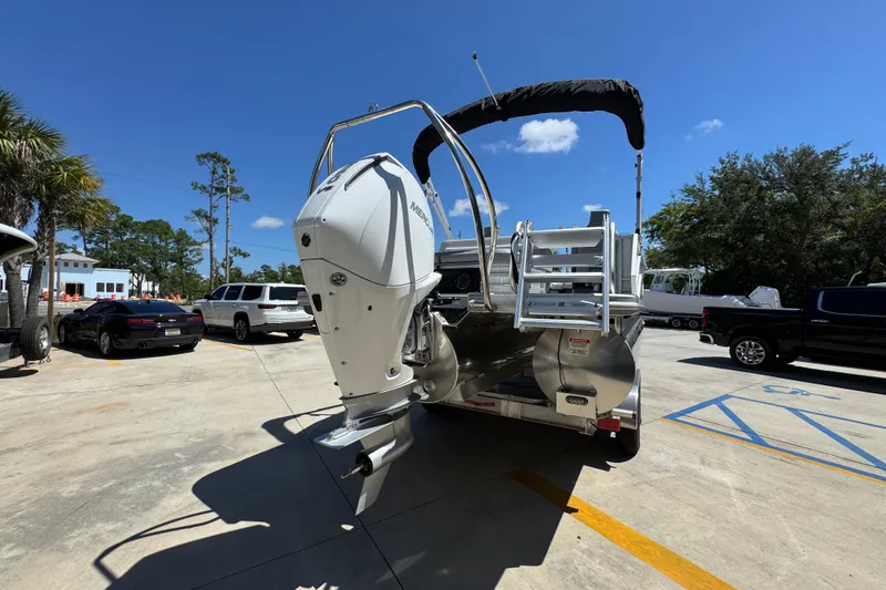Slide: The Image of 2026 Bennington 24 MSB pontoon boat with Mercury outboard motor in a parking lot. - 13