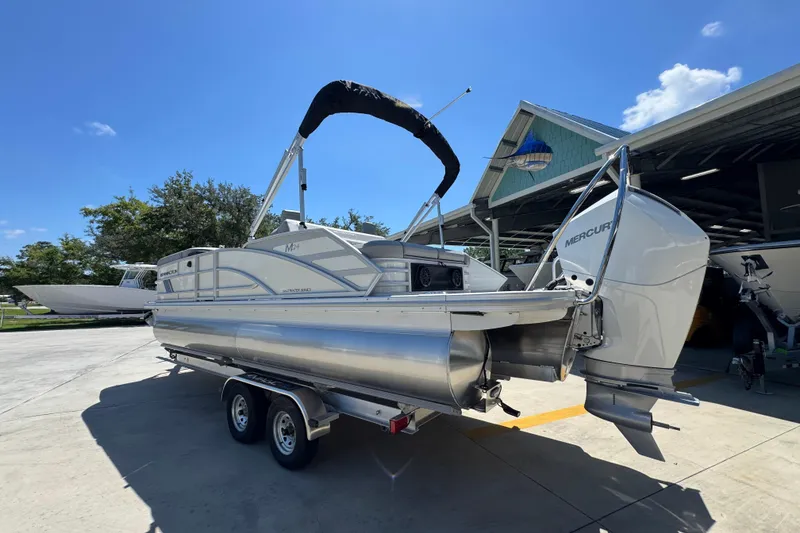 Slide: The Image of 2026 Bennington 24 MSB pontoon boat with Mercury outboard engine on trailer. - 16