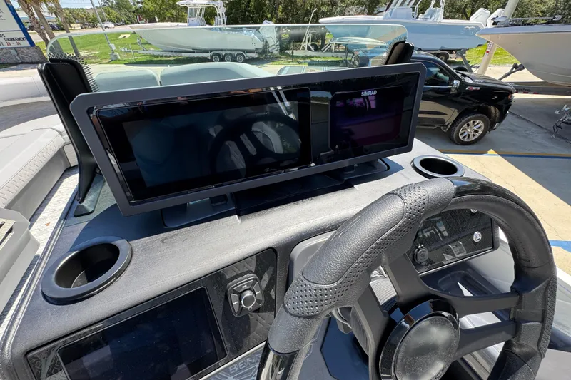 Slide: The Image of 2026 Bennington 24 MSB boat dashboard with steering wheel and Simrad display. - 25