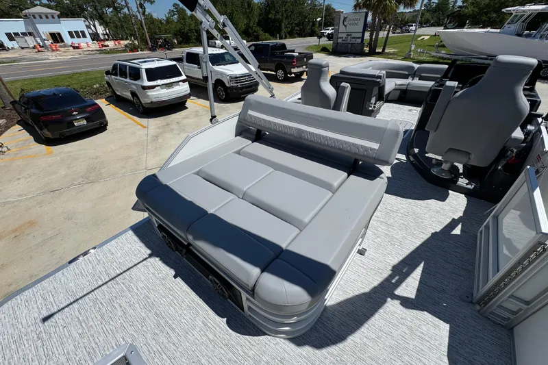 Slide: The Image of 2026 Bennington 24 MSB pontoon boat with gray seating, parked in a lot. - 33