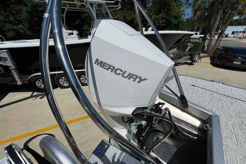 Slide: The Image of 2026 Bennington 24 MSB with Mercury outboard engine, parked outdoors. - 38