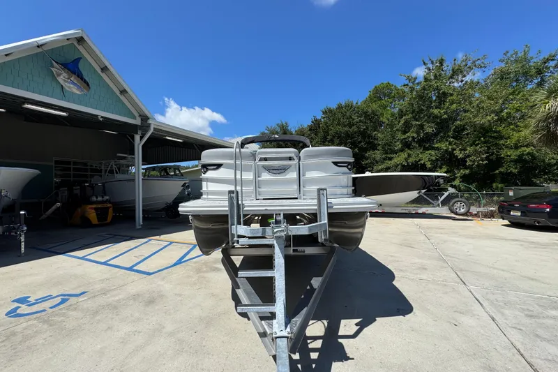 Slide: The Image of 2026 Bennington 24 MSB pontoon boat on trailer under clear blue sky. - 6