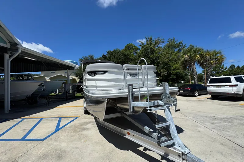 Slide: The Image of 2026 Bennington 24 MSB pontoon boat on trailer under clear blue sky. - 7