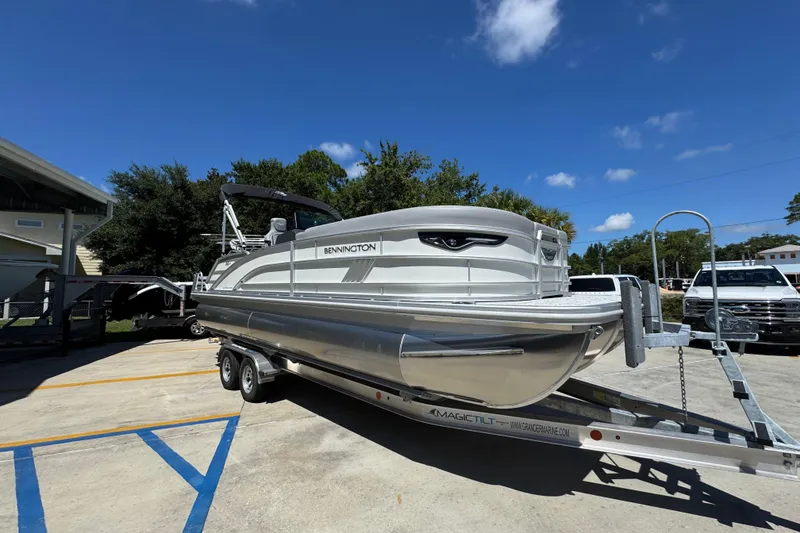 Slide: The Image of 2026 Bennington 24 MSB pontoon boat on trailer under clear blue sky. - 8
