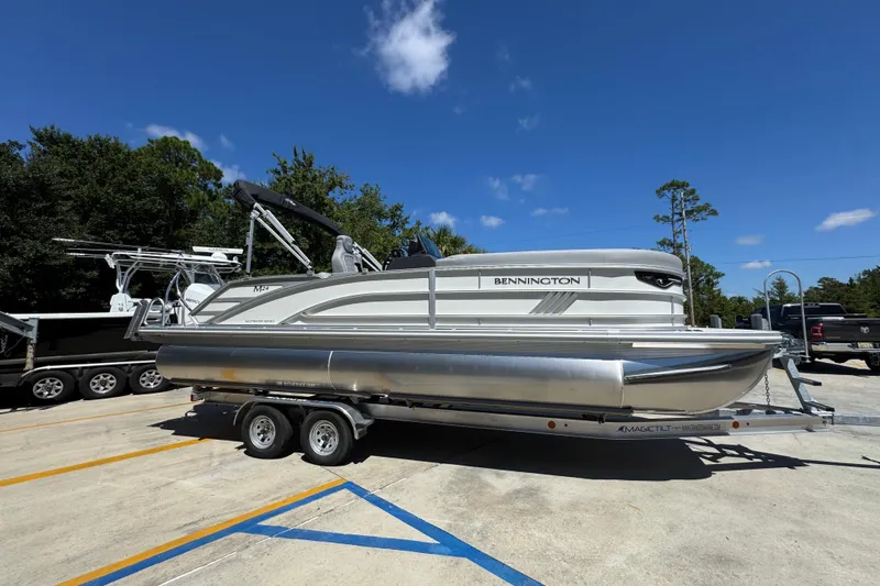 Slide: The Image of 2026 Bennington 24 MSB pontoon boat on trailer under clear blue sky. - 9