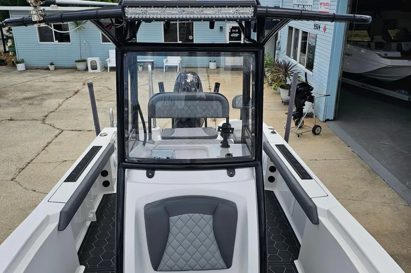 Slide: The Image of 2024 Polar 220CC boat with sleek design and modern interior, docked near a blue building. - 2