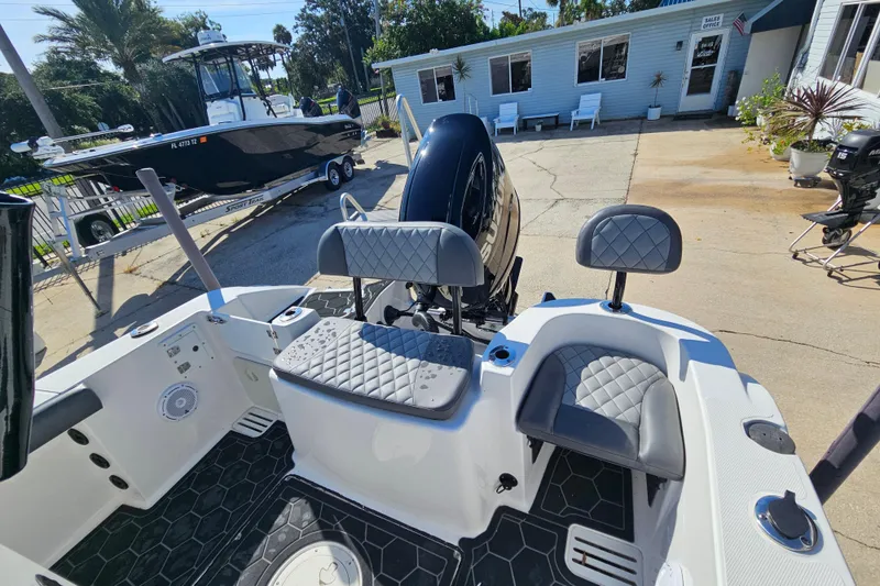 Slide: The Image of 2024 Polar 220CC boat interior with seating and motor, parked near sales office. - 5