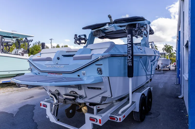 Slide: The Image of 2026 Nautique Super Air Nautique G23 boat on trailer, rear view, blue and white design. - 14