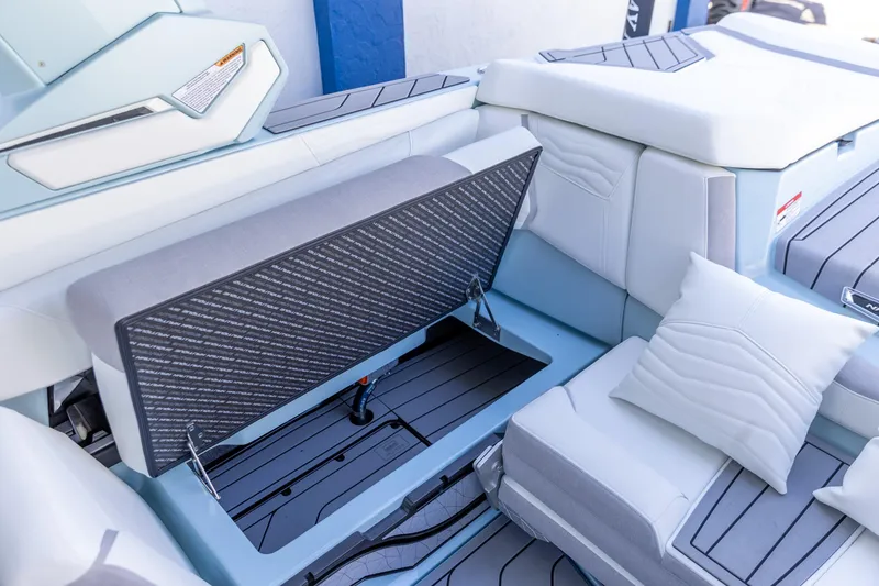 Slide: The Image of 2026 Nautique Super Air Nautique G23 interior seating with storage compartment open. - 4