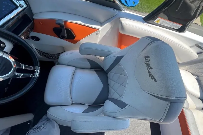Slide: The Image of 2015 Tigé RZ 2 boat interior with gray and orange seating and steering wheel. - 10