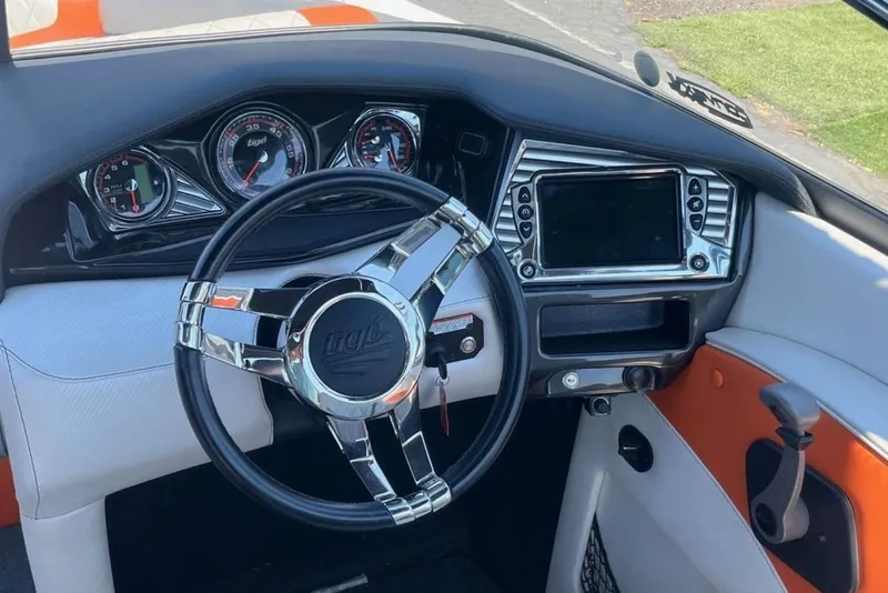 Slide: The Image of 2015 Tigé RZ 2 boat dashboard with chrome steering wheel and modern gauges. - 13