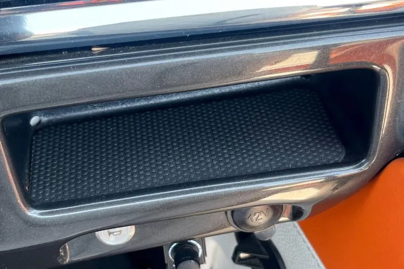 Slide: The Image of 2015 Tigé RZ 2 boat dashboard with storage compartment and 12V outlet. - 16