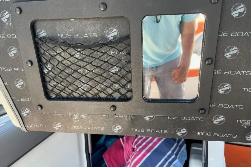Slide: The Image of 2015 Tigé RZ 2 boat interior with branded panel and storage net. - 22