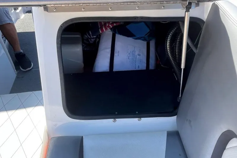 Slide: The Image of 2015 Tigé RZ 2 boat storage compartment with open hatch and visible contents. - 28