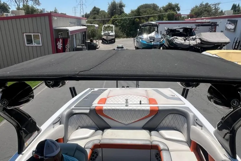 Slide: The Image of 2015 Tigé RZ 2 boat with black canopy and orange-accented seating, parked at a marina. - 31