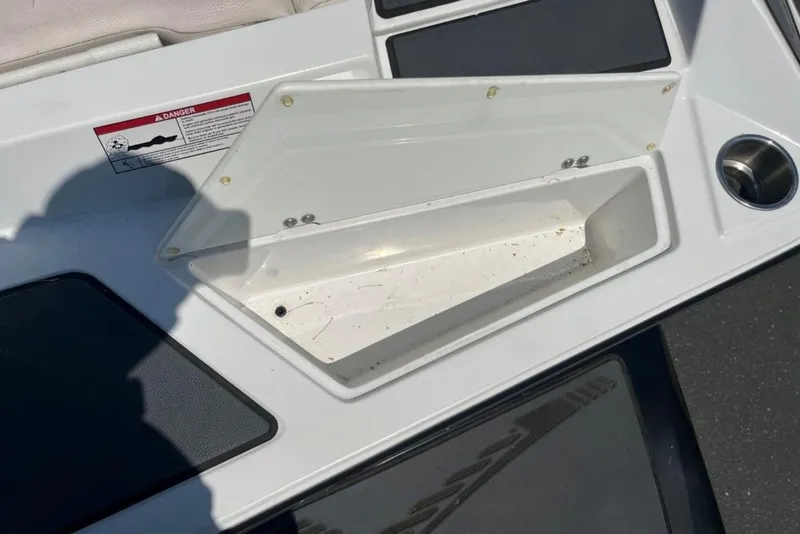 Slide: The Image of Open storage compartment on 2015 Tigé RZ 2 boat with warning label. - 5