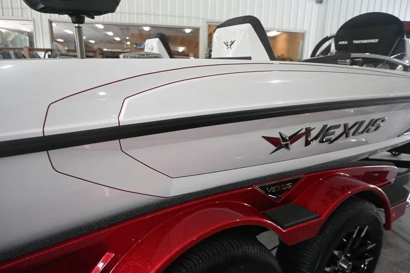 Slide: The Image of 2026 Vexus VX s21 boat with sleek white and red design in showroom. - 3