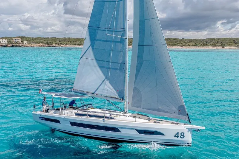 Slide: The Image of Sailing yacht Dufour 48, 2026 model, cruising on turquoise waters under cloudy skies. - 16