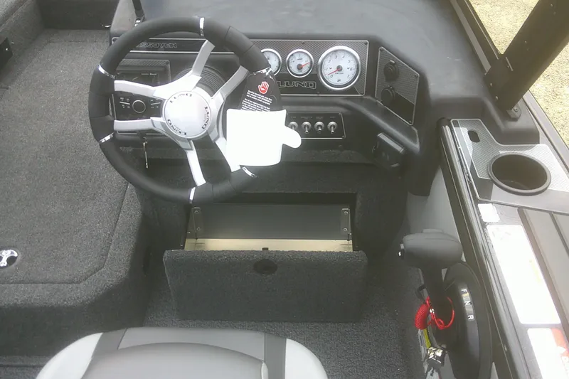 Slide: The Image of 2026 Lund 1875 Crossover XS boat cockpit with steering wheel and dashboard controls. - 10