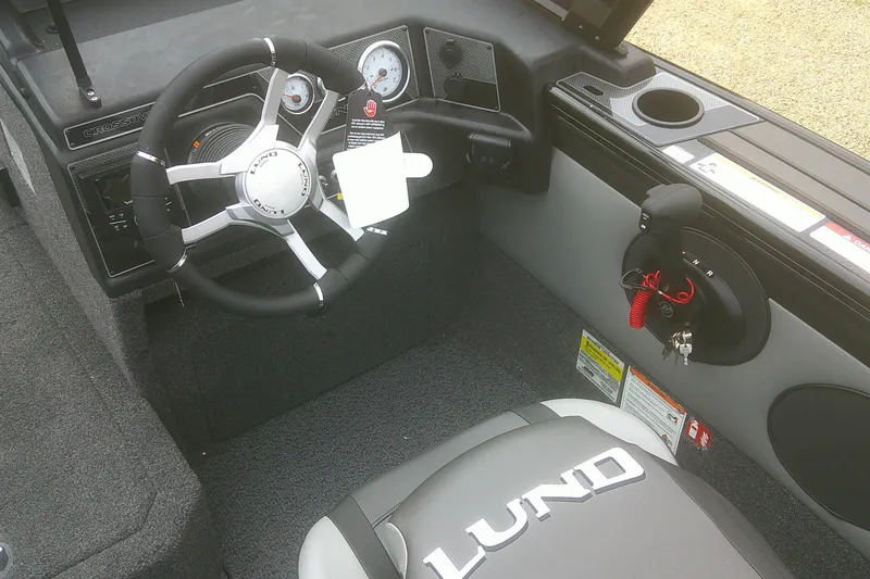 Slide: The Image of 2026 Lund 1875 Crossover XS boat interior with steering wheel and dashboard controls. - 8