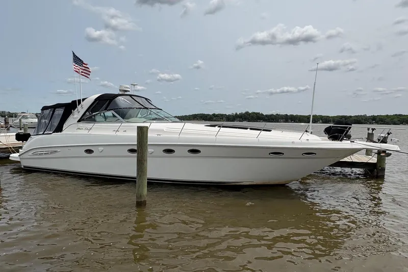 The Image of 2001 Sea Ray 460 Sundancer yacht docked, featuring sleek design and American flag. - 0