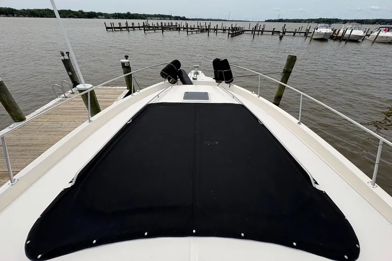Slide: The Image of Bow view of 2001 Sea Ray 460 Sundancer yacht docked by the water. - 18