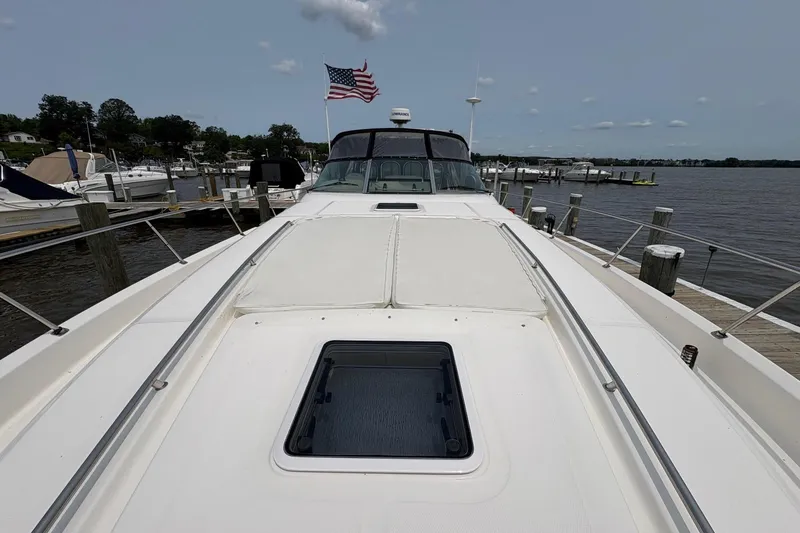 Slide: The Image of 2001 Sea Ray 460 Sundancer yacht docked at marina with American flag. - 19
