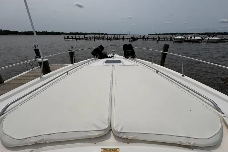 Slide: The Image of 2001 Sea Ray 460 Sundancer yacht docked, featuring spacious deck and serene waterfront view. - 20