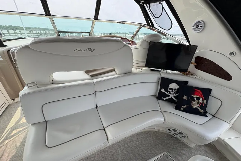 Slide: The Image of Interior of 2001 Sea Ray 460 Sundancer with white seating and pirate-themed pillows. - 28