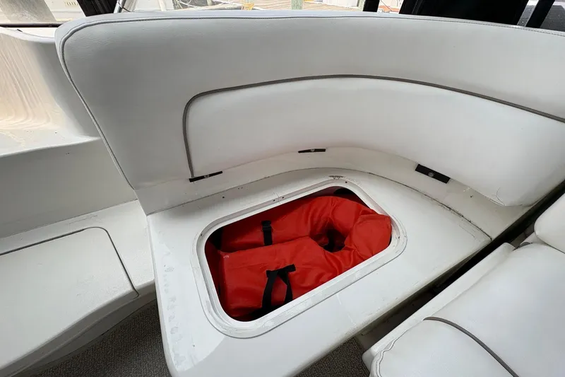 Slide: The Image of 2001 Sea Ray 460 Sundancer boat seat storage with red life jackets inside. - 29