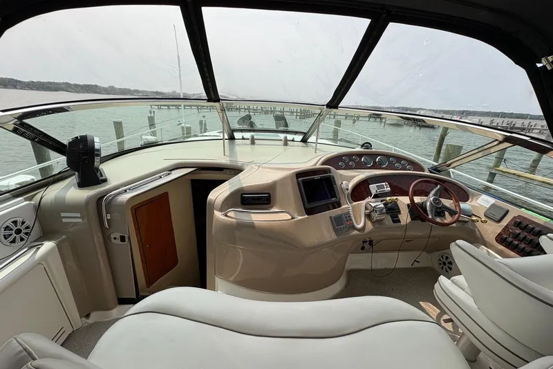 Slide: The Image of 2001 Sea Ray 460 Sundancer helm with steering wheel, navigation equipment, and waterfront view. - 35