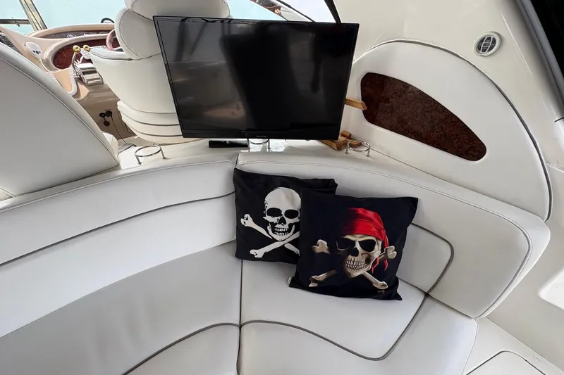 Slide: The Image of Interior of 2001 Sea Ray 460 Sundancer with pirate-themed pillows and a mounted TV. - 36