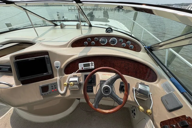 Slide: The Image of 2001 Sea Ray 460 Sundancer helm with steering wheel, gauges, and navigation equipment. - 38