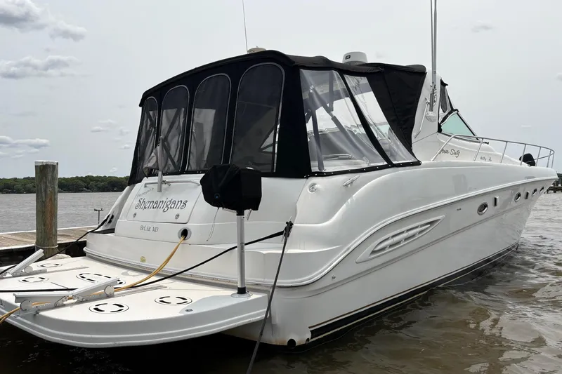 Slide: The Image of 2001 Sea Ray 460 Sundancer yacht docked, featuring sleek design and black canopy. - 4