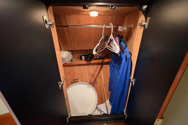 Slide: The Image of Wooden closet interior on 2001 Sea Ray 460 Sundancer yacht with hangers and clothes. - 47