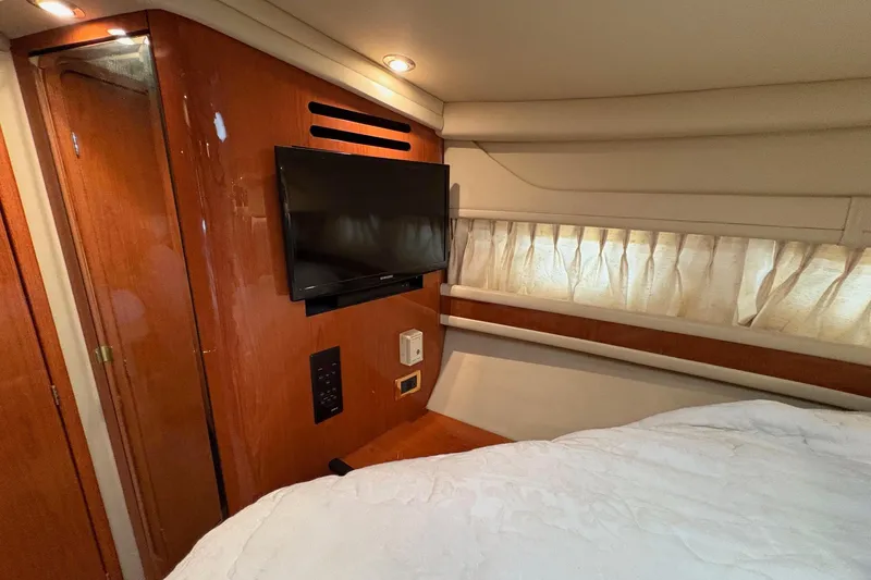 Slide: The Image of 2001 Sea Ray 460 Sundancer cabin interior with TV, wood paneling, and bed. - 49