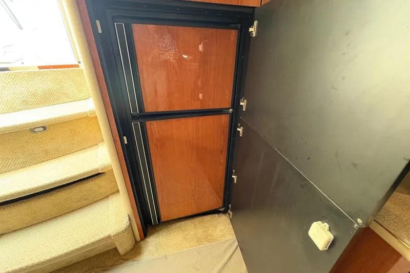 Slide: The Image of Interior of 2001 Sea Ray 460 Sundancer showing open cabinet and carpeted stairs. - 55